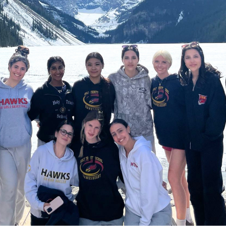 A bunch of students posing for an image in front of a lake